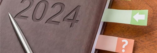 Agenda 2024 avec un stylo posé dessus et des onglets colorés visibles sur le côté