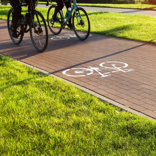 Personnes roulant à vélo sur une piste cyclable ensoleillée
