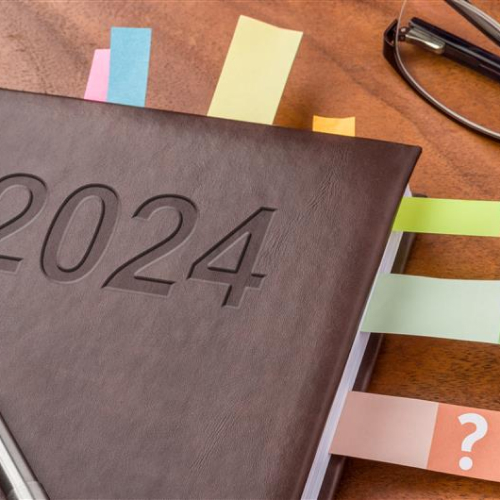 Agenda 2024 sur une table avec des onglets colorés et une paire de lunettes