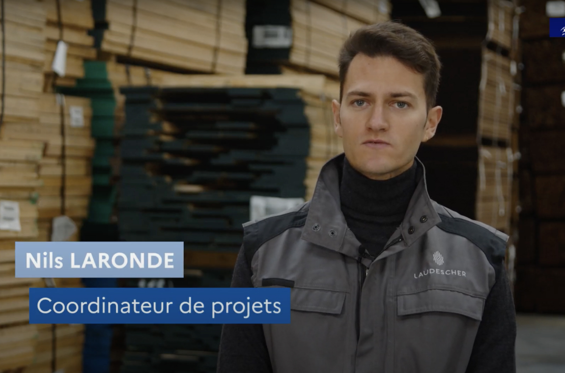 Nils Laronde Coordinateur de projets, devant des piles de bois