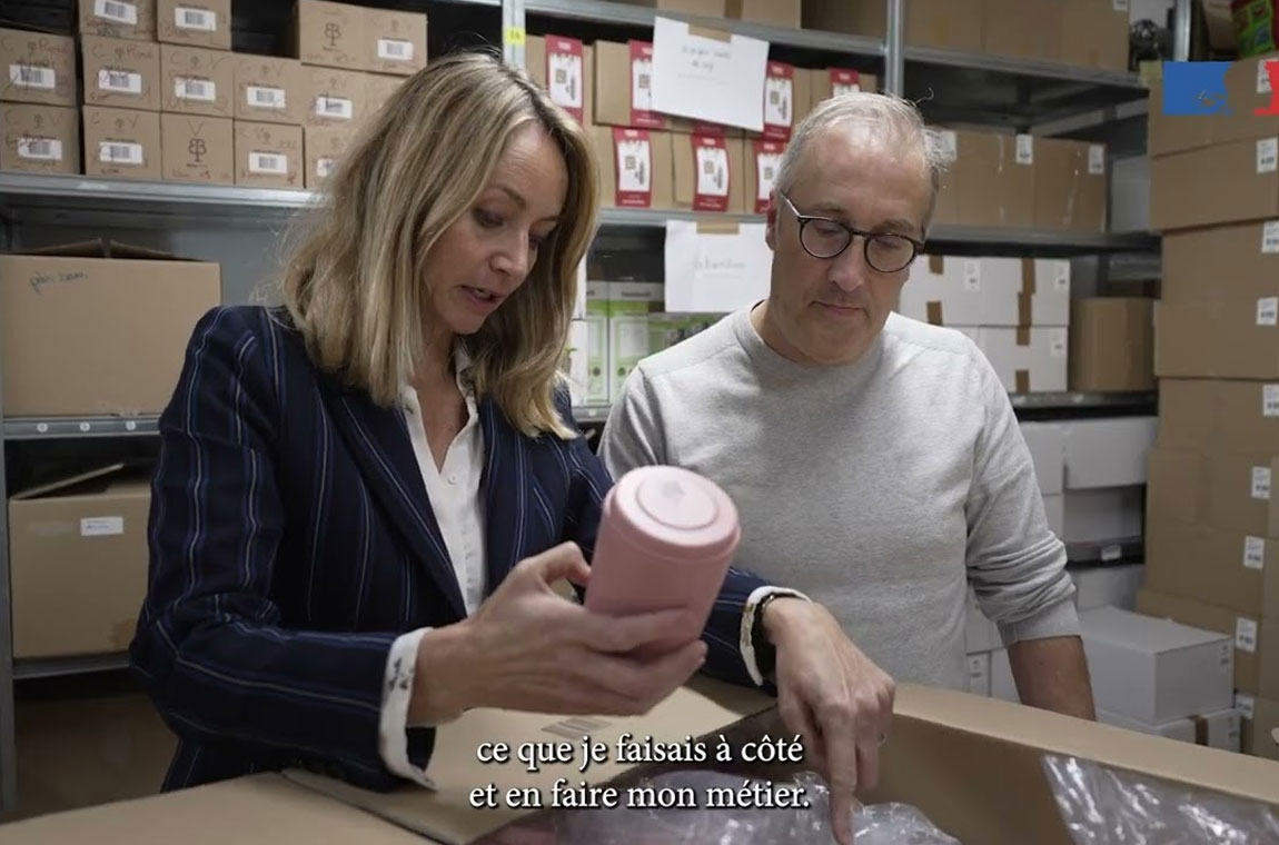 Personnes examinant un contenant dans un espace de stockage rempli de cartons