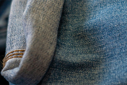 Gros plan sur un tissu en denim avec un ourlet visible